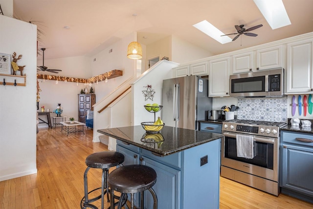 kitchen with white cabinetry, ceiling fan, lofted ceiling with skylight, and high end appliances