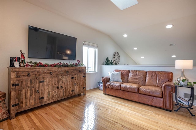 living room with lofted ceiling with skylight and light wood-type flooring