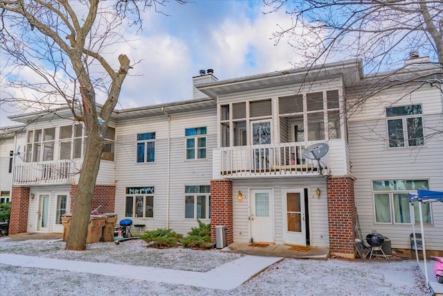 view of front of house with central air condition unit and a sunroom