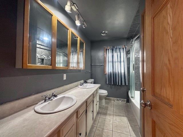 803 E Birch St, Spencer, WI 54479 - full bathroom featuring combined bath / shower with glass door, vanity, tile patterned flooring, and toilet