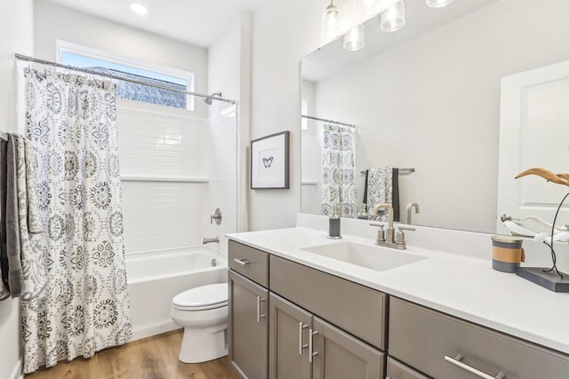 full bath featuring vanity, shower / bath combo with shower curtain, wood finished floors, and toilet