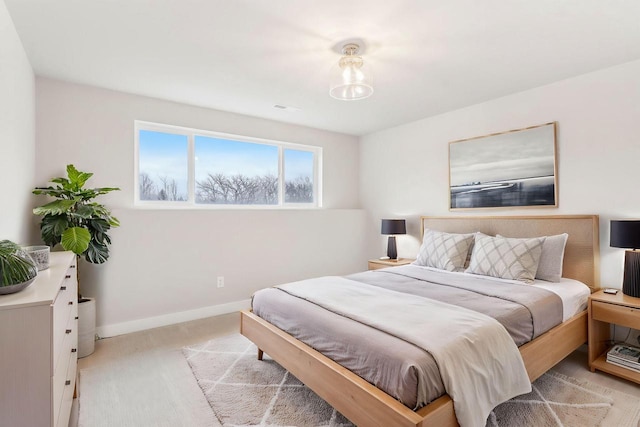 bedroom featuring light carpet and baseboards