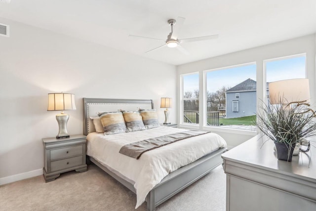 bedroom with light carpet, ceiling fan, and baseboards