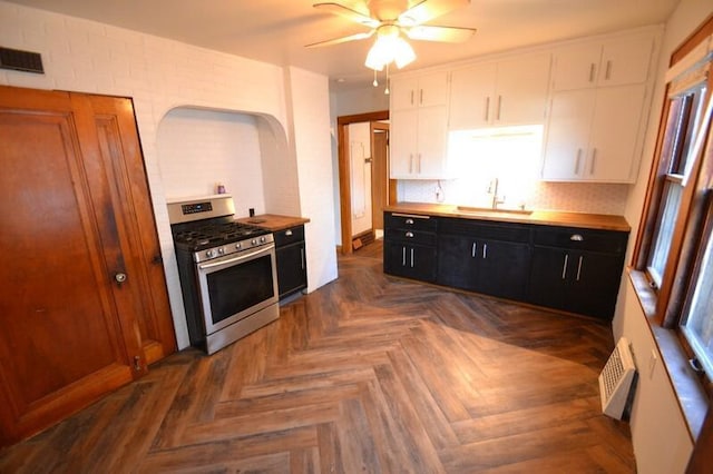 kitchen featuring white cabinets, dark parquet floors, sink, tasteful backsplash, and gas stove