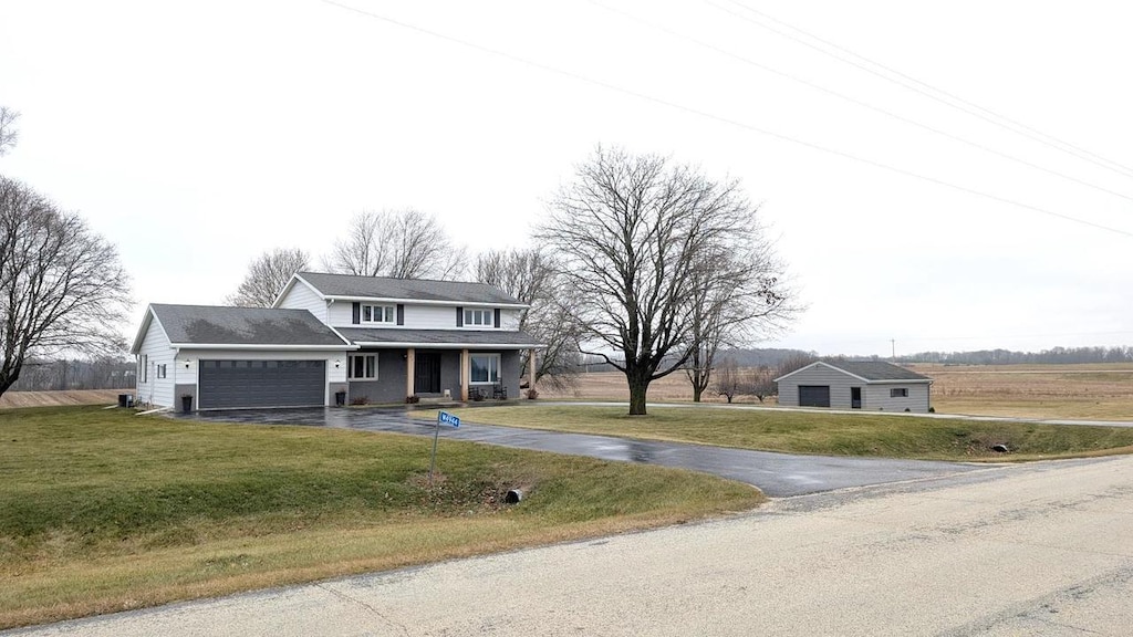 view of front of property featuring a front lawn, a porch, and a garage