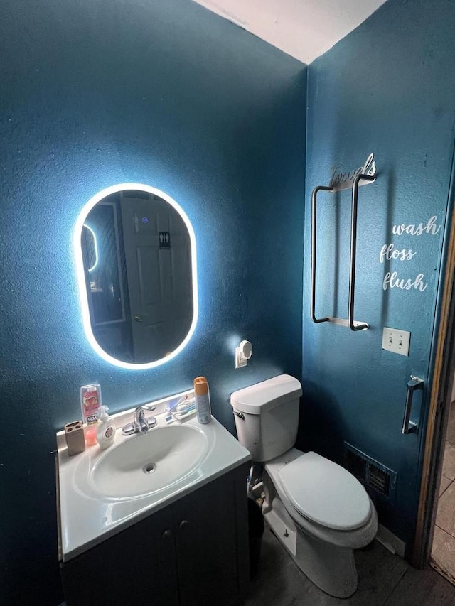 bathroom with tile patterned flooring, vanity, and toilet