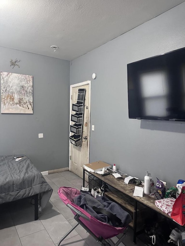 bedroom featuring light tile patterned flooring and a textured ceiling