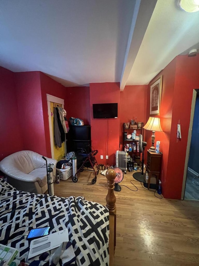 interior space with hardwood / wood-style floors, beamed ceiling, and a closet