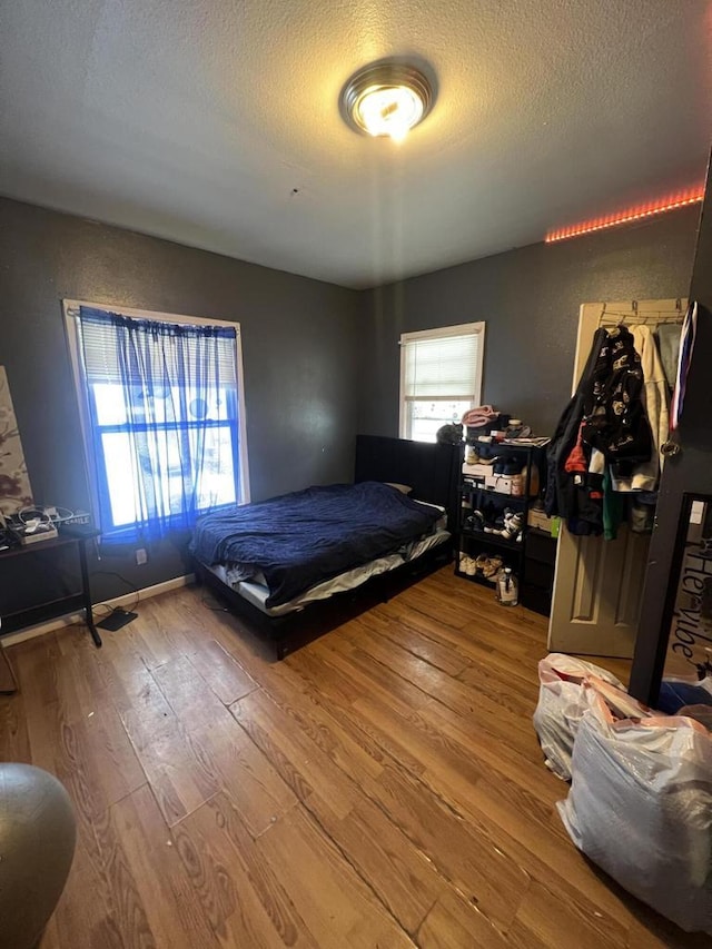 bedroom featuring hardwood / wood-style floors and a textured ceiling