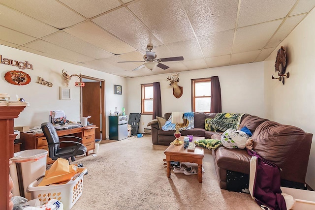 living room featuring carpet, baseboard heating, a drop ceiling, and ceiling fan