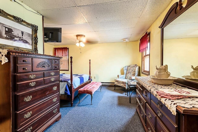 carpeted bedroom featuring ceiling fan and a drop ceiling