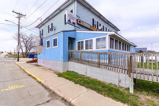 view of side of property with a sunroom and a wooden deck