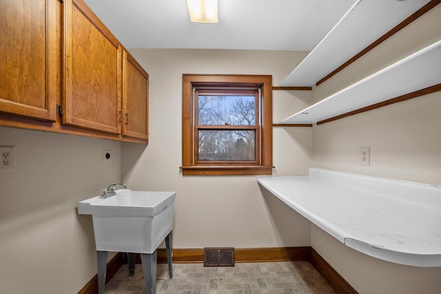 clothes washing area featuring hookup for an electric dryer and cabinets