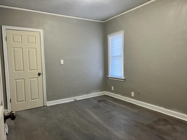 empty room featuring dark hardwood / wood-style floors and ornamental molding