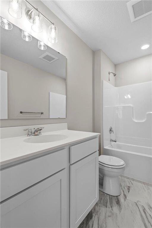 full bathroom featuring vanity, a textured ceiling, bathing tub / shower combination, and toilet