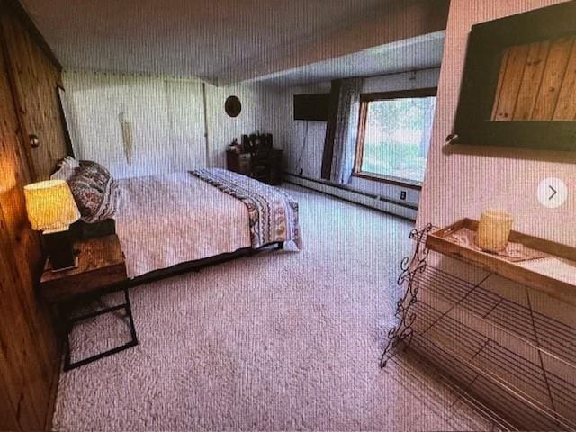 carpeted bedroom featuring baseboard heating and wood walls