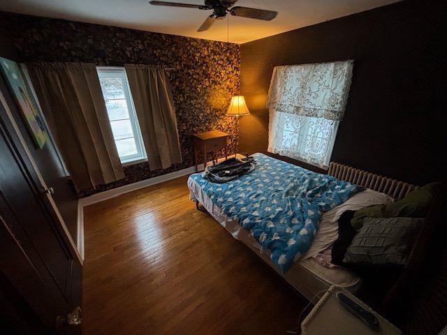 bedroom with ceiling fan and hardwood / wood-style flooring