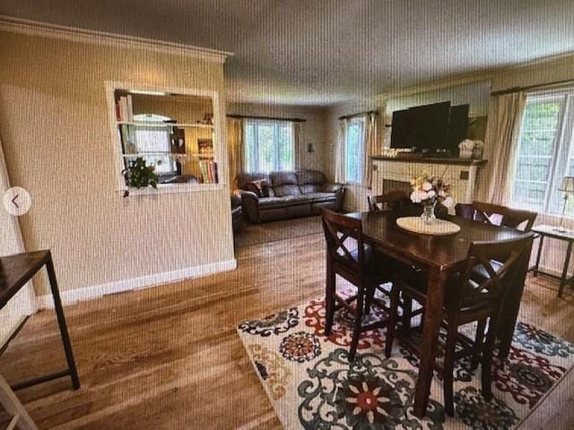 dining room featuring crown molding and a tiled fireplace