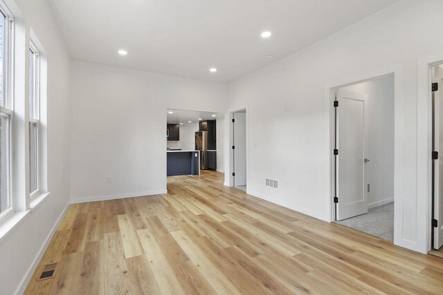 unfurnished room featuring a wealth of natural light and light hardwood / wood-style flooring