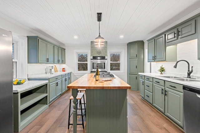 kitchen with a center island, sink, stainless steel appliances, wooden counters, and hardwood / wood-style flooring