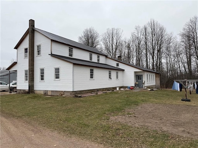 rear view of property featuring a lawn