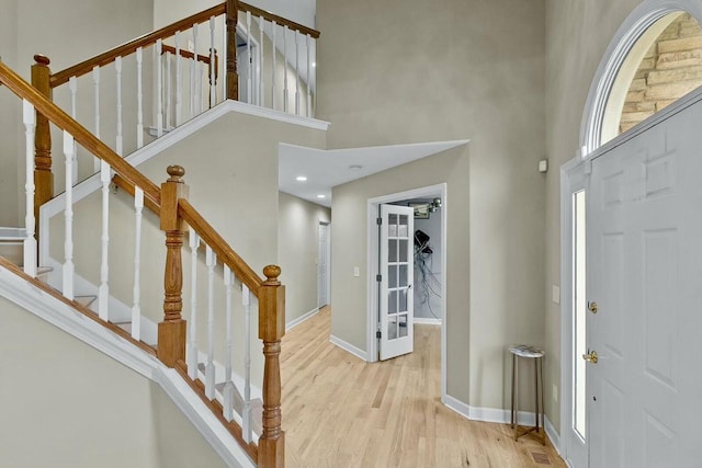 entrance foyer with light hardwood / wood-style flooring and a towering ceiling