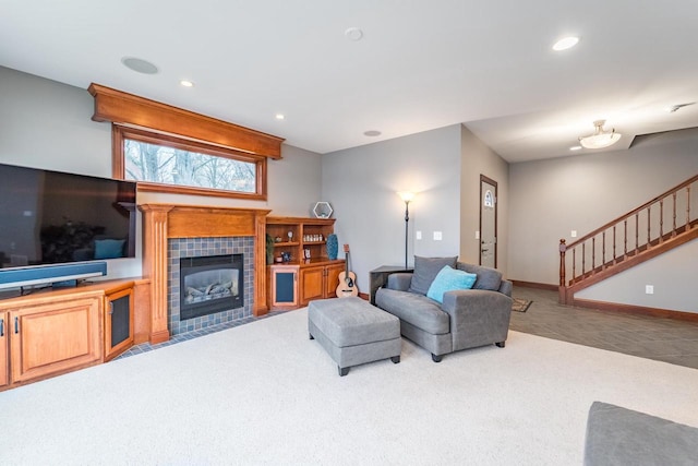 carpeted living room featuring a tiled fireplace