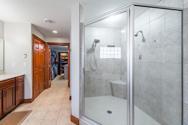 bathroom with tile patterned flooring, vanity, and walk in shower