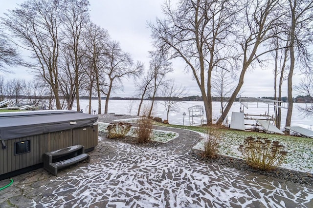 snow covered patio featuring a hot tub