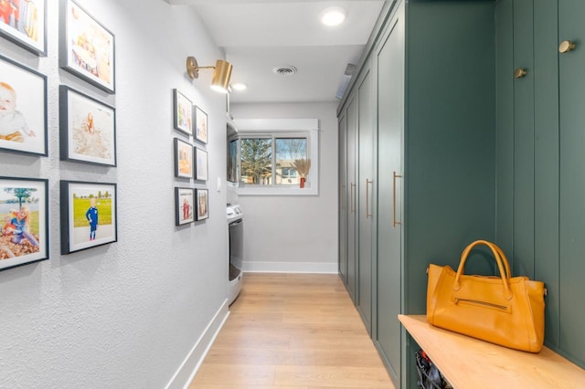 hallway featuring washer / clothes dryer and light wood-type flooring