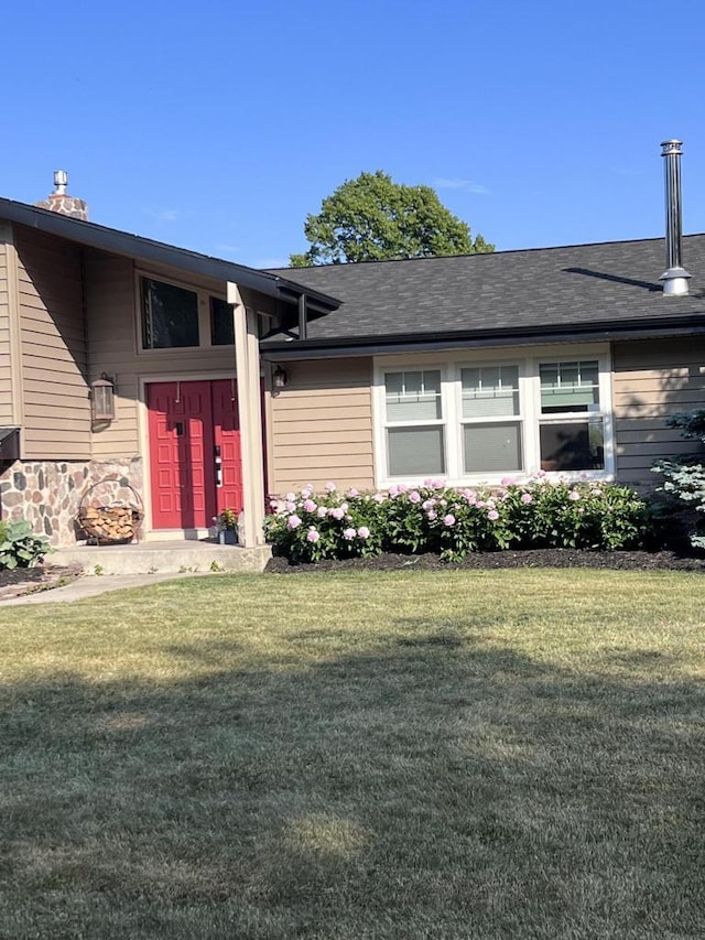 view of exterior entry with a yard