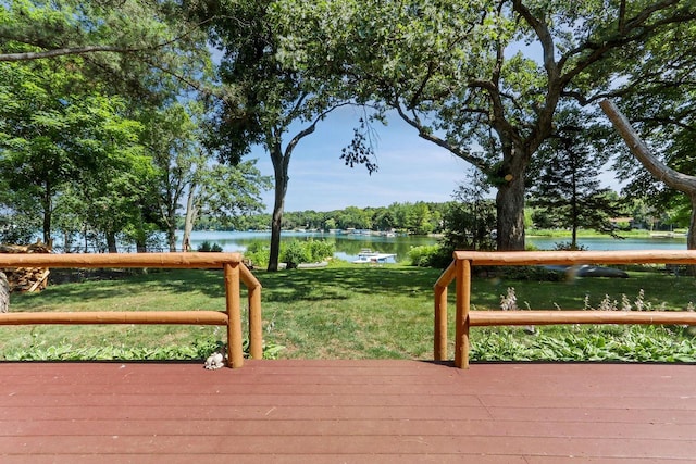 wooden terrace with a lawn and a water view