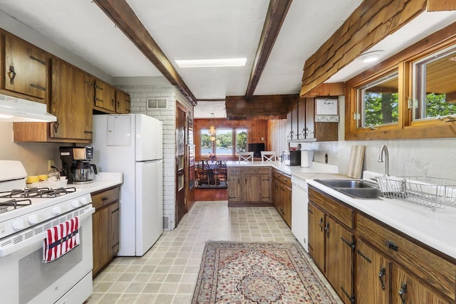 kitchen with sink, beamed ceiling, and white appliances