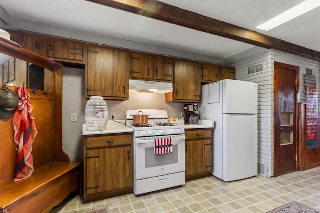 kitchen with white appliances and brick wall