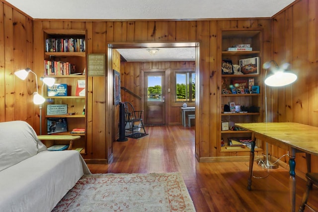 interior space featuring wood walls, built in features, a textured ceiling, and hardwood / wood-style flooring