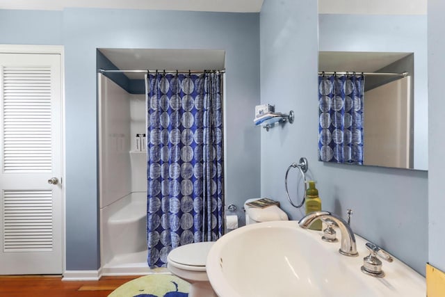 bathroom featuring curtained shower, sink, wood-type flooring, and toilet