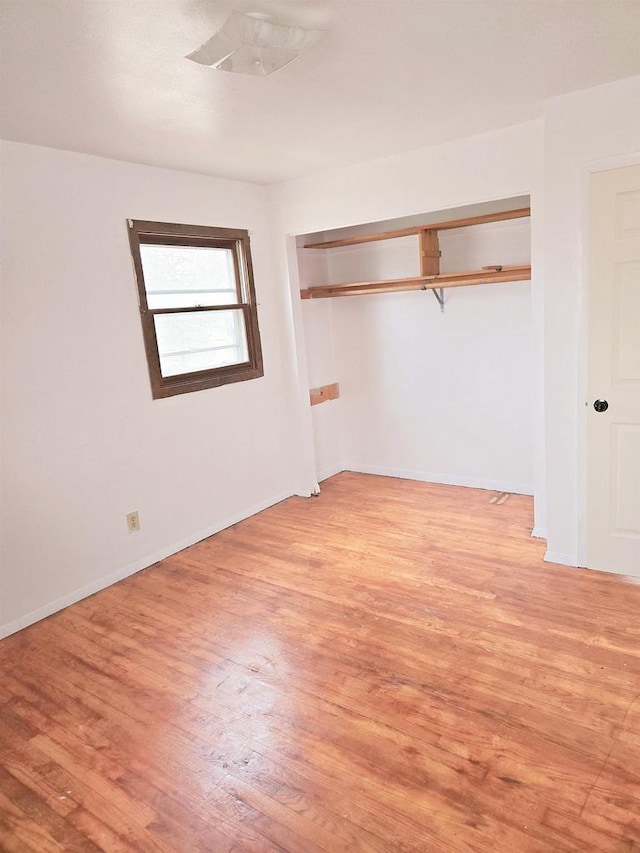 unfurnished bedroom with a closet and light hardwood / wood-style floors