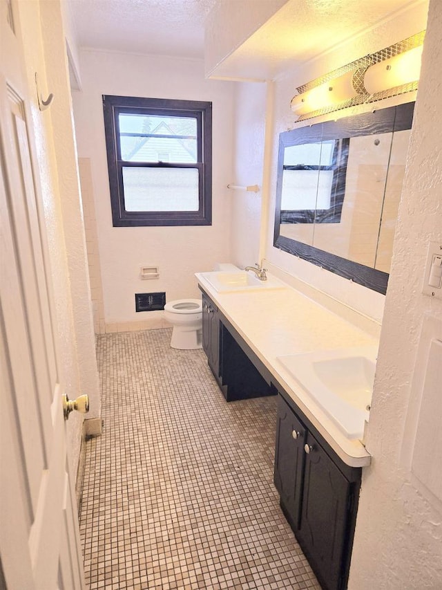 bathroom featuring tile patterned floors, vanity, a textured ceiling, and toilet