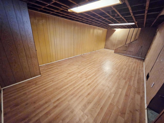 basement featuring hardwood / wood-style floors and wooden walls