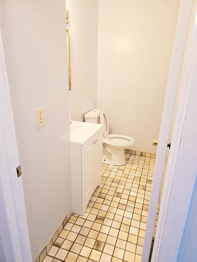 bathroom with tile patterned flooring, vanity, and toilet