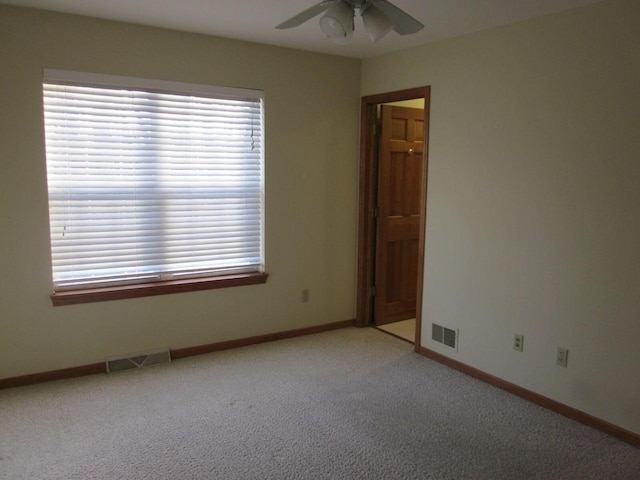 empty room featuring light colored carpet and ceiling fan