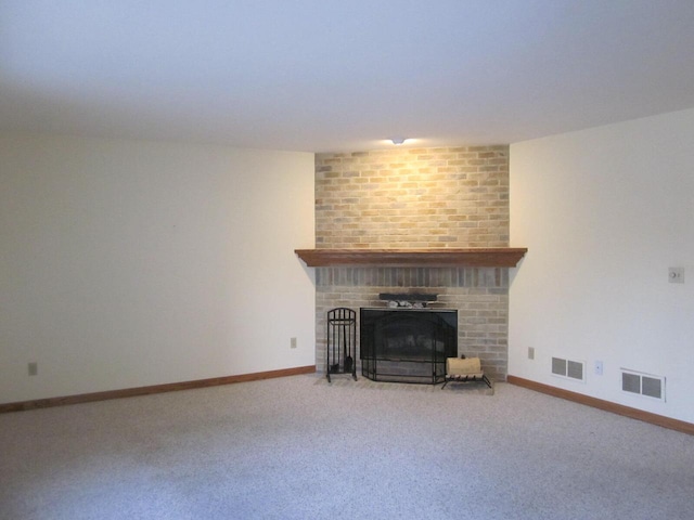 unfurnished living room featuring carpet flooring and a brick fireplace