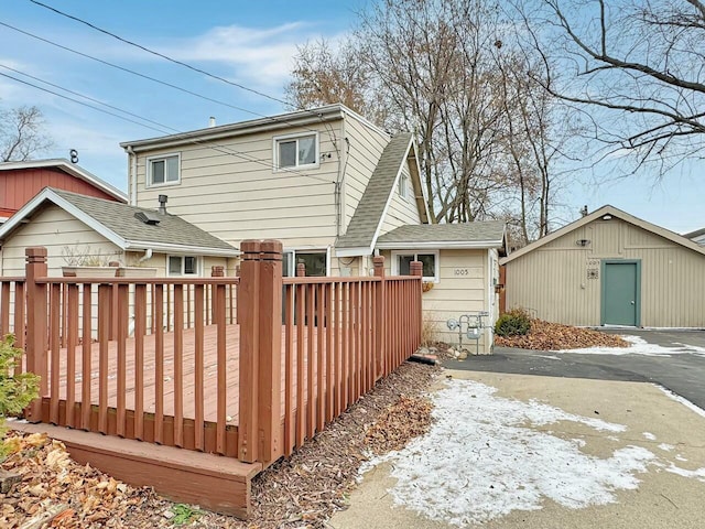 rear view of property with a deck and an outdoor structure