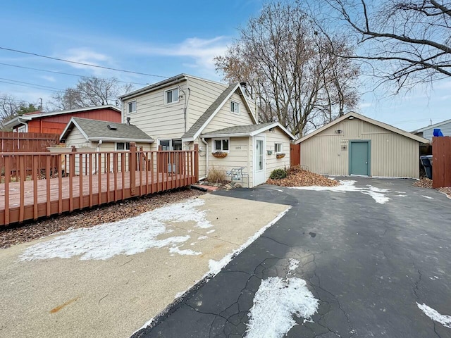 back of house featuring an outbuilding and a wooden deck