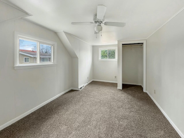 additional living space with ceiling fan, plenty of natural light, and carpet