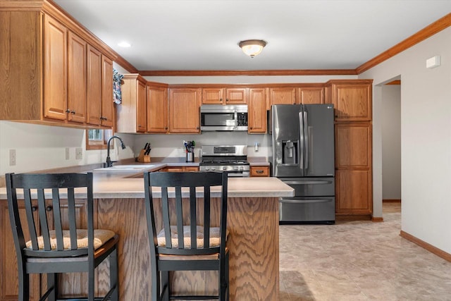 kitchen featuring sink, stainless steel appliances, kitchen peninsula, crown molding, and a breakfast bar area