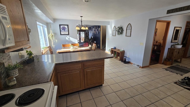 kitchen featuring pendant lighting, a notable chandelier, range, and light tile patterned floors