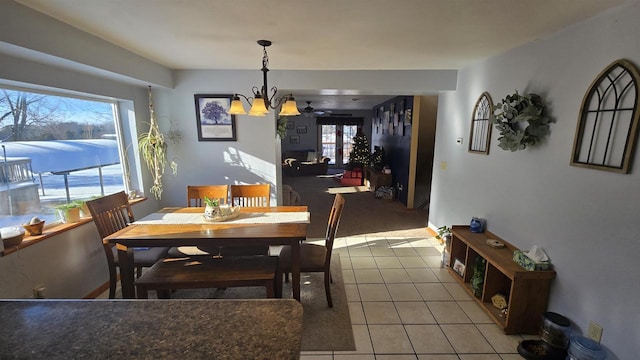 tiled dining space with a wealth of natural light and an inviting chandelier