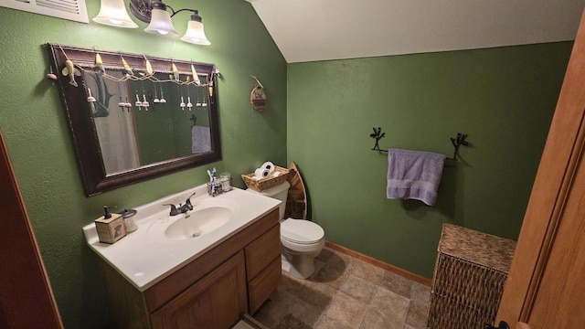 bathroom with vanity, toilet, and vaulted ceiling