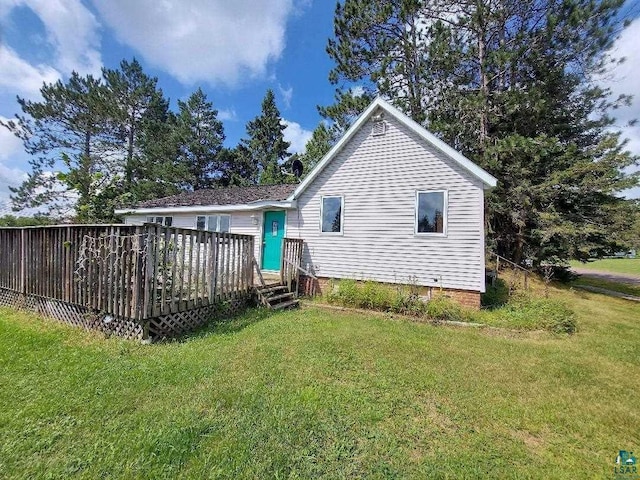 back of property with a lawn and a wooden deck